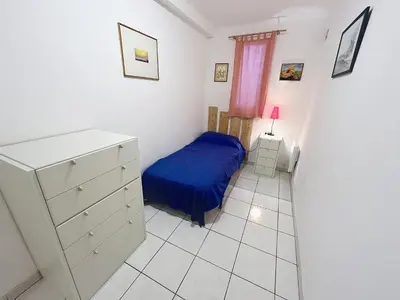 a small bedroom with a blue bed and a dresser at 2 bedroom Pradignac 305 in Cannes