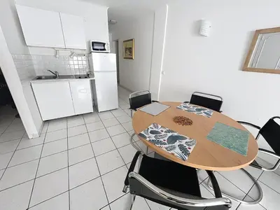 a kitchen with a table and chairs in a room at 2 bedroom Pradignac 305 in Cannes