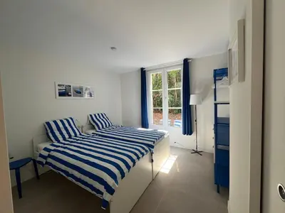 a bedroom with two beds and a window at Elegant 3-BR Cannes Garden Condo - 5 Min Walk to Beach - behind Martinez in Cannes