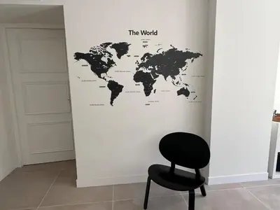 a black chair and a map of the world on a wall at Elegant 3-BR Cannes Garden Condo - 5 Min Walk to Beach - behind Martinez in Cannes