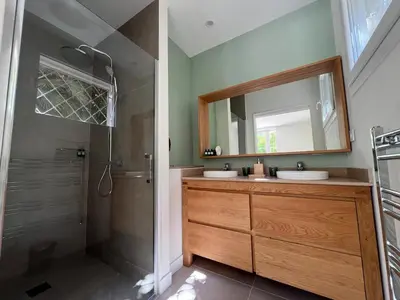 a bathroom with two sinks and a shower with a mirror at Elegant 3-BR Cannes Garden Condo - 5 Min Walk to Beach - behind Martinez in Cannes