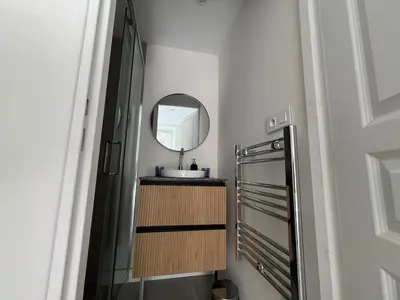 a small bathroom with a sink and a mirror at Elegant 3-BR Cannes Garden Condo - 5 Min Walk to Beach - behind Martinez in Cannes