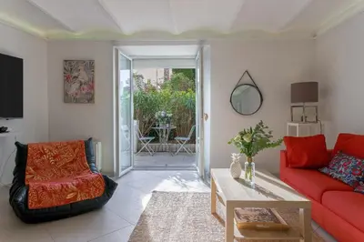a living room with a red couch and a table at Louison balcony, quiet area, 7mn from beach in Cannes