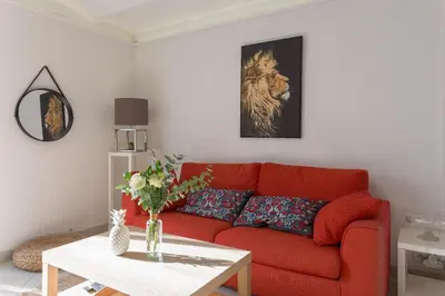 a living room with a red couch and a table at Louison balcony, quiet area, 7mn from beach in Cannes
