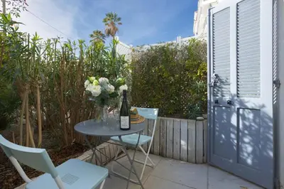 a table with a bottle of wine and flowers on it at Louison balcony, quiet area, 7mn from beach in Cannes
