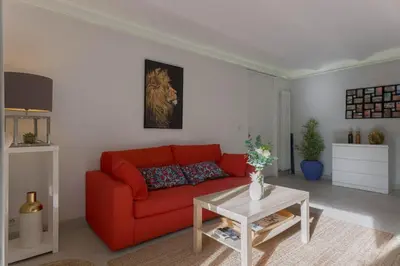 a living room with a red couch and a table at Louison balcony, quiet area, 7mn from beach in Cannes