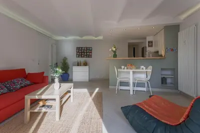 a living room with a red couch and a table at Louison balcony, quiet area, 7mn from beach in Cannes