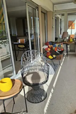 a room with a chair and tables in a room at Appartement Ima in Cannes