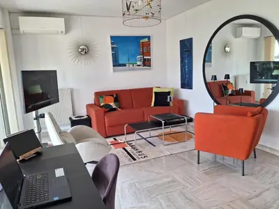 a living room with a red couch and a mirror at Appartement Ima in Cannes