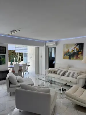 a living room with white couches and a table at Appartement lumineux centre ville avec jardin in Cannes