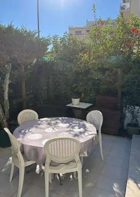 a table with three chairs and a table and a table and chairs at Appartement lumineux centre ville avec jardin in Cannes