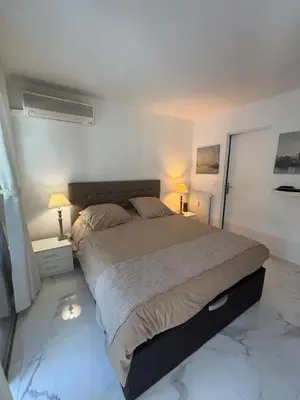 a bedroom with a large bed with two lamps at Appartement lumineux centre ville avec jardin in Cannes