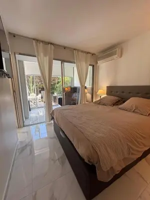 a bedroom with a bed and a large window at Appartement lumineux centre ville avec jardin in Cannes