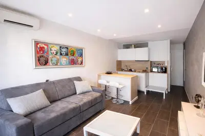 a living room with a couch and a kitchen at Le Palm - Croisette - Beach - Casino - Wi-Fi in Cannes