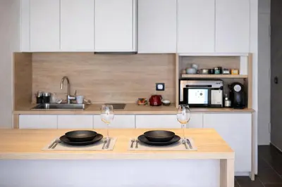 a kitchen with two plates and two wine glasses at Le Palm - Croisette - Beach - Casino - Wi-Fi in Cannes