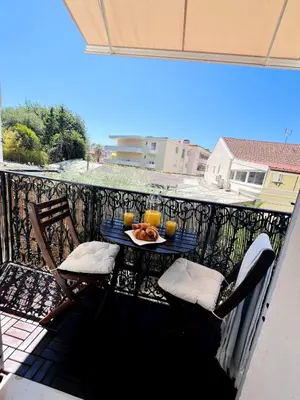 a table with a plate of food on a balcony at Appartement Calme Proche Plages in Cannes