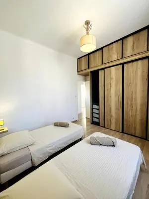 two beds in a room with white walls at Appartement Calme Proche Plages in Cannes