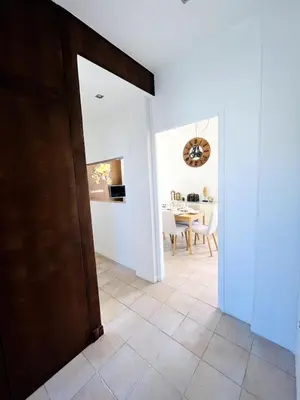 a hallway with a dining room and a table at Appartement Calme Proche Plages in Cannes