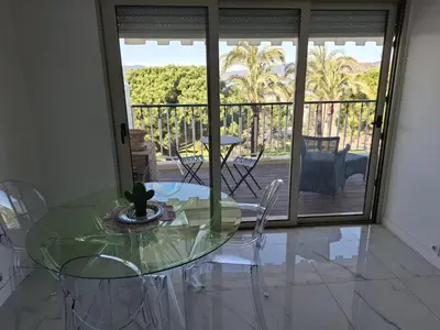 a glass table and chairs in a room with a balcony at Viva Riviera Studio Croisette Terrace Sea View in Cannes