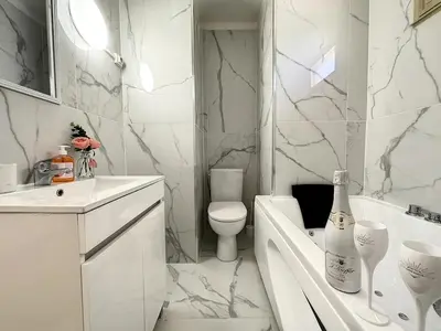 a white bathroom with a tub and a toilet and a sink at Studio Évasion Balneo, Clim, Wifi, Netflix, Palais in Cannes