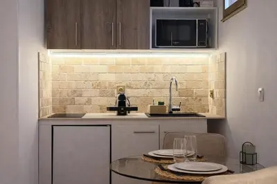 a kitchen with a sink and a table with plates on it at Studio Évasion Balneo, Clim, Wifi, Netflix, Palais in Cannes