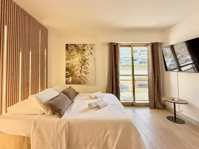 a bedroom with a large bed and a large window at Studio Évasion Balneo, Clim, Wifi, Netflix, Palais in Cannes