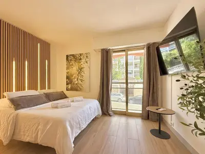 a bedroom with a bed and a large window at Studio Évasion Balneo, Clim, Wifi, Netflix, Palais in Cannes