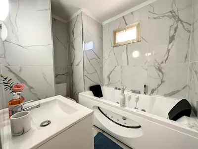 a white bathroom with a sink and a mirror at Studio Évasion Balneo, Clim, Wifi, Netflix, Palais in Cannes