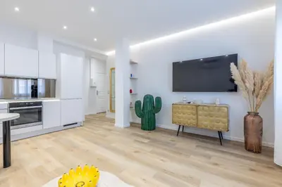 a living room with a flat screen tv on a wall at LB Vacation Rentals I Fully Renovated Apt Min from Palais - Beach in Cannes