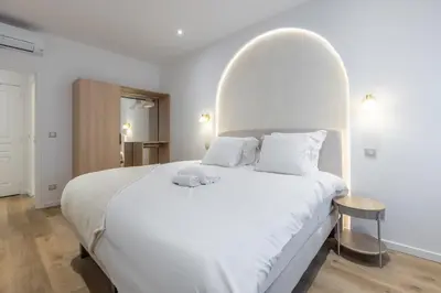 a bed with towels and a gold object on it at LB Vacation Rentals I Fully Renovated Apt Min from Palais - Beach in Cannes