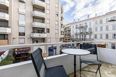 a balcony with a table and chairs and some buildings at Luxury apt 5 min from the beach and La Croisette in Cannes