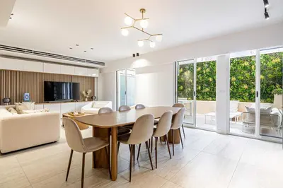 a dining room and living room with a table and chairs at Luxury apt 5 min from the beach and La Croisette in Cannes