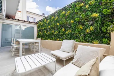 a green wall with a table and chairs on a patio at Luxury apt 5 min from the beach and La Croisette in Cannes