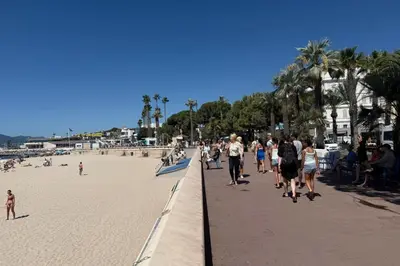 a group of people walking on the beach at Charming studio with terrace in Cannes