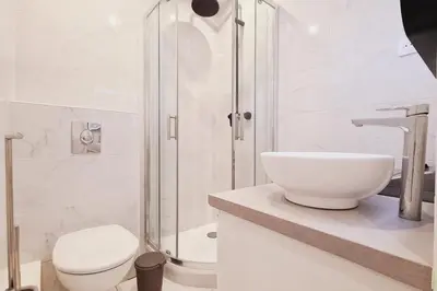 a bathroom with a toilet and a glass shower at Charming studio with terrace in Cannes