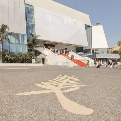 a building with a sign on the ground in the street at Appartement moderne et chaleureux à 2 minutes du Palais in Cannes
