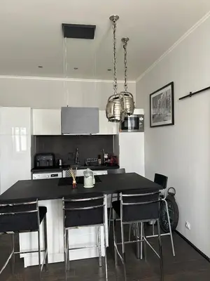 a kitchen with a black table and chairs at Appartement moderne et chaleureux à 2 minutes du Palais in Cannes