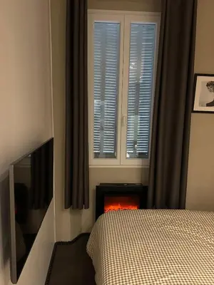 a bedroom with a bed and a fire place at Appartement moderne et chaleureux à 2 minutes du Palais in Cannes