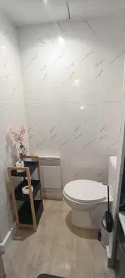 a bathroom with a toilet and a white wall at Apartmens 1-st line Cannes Beach in Cannes