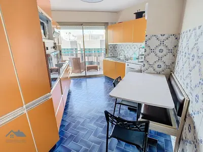 a small kitchen with a table and a table and chairs at Appartements derrière Croisette in Cannes