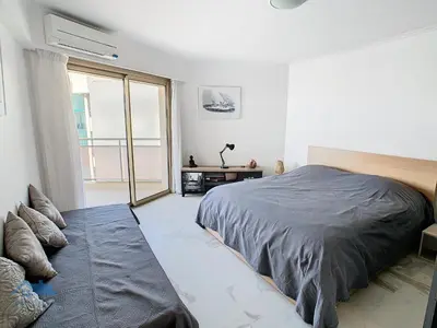 a bedroom with a large bed and a window at Appartements derrière Croisette in Cannes
