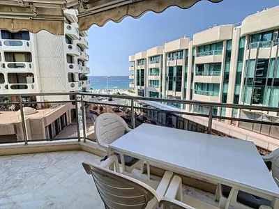 a balcony with a table and chairs and some buildings at Appartements derrière Croisette in Cannes