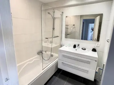 a white bathroom with a sink and a shower at Appartements derrière Croisette in Cannes
