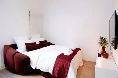 a bedroom with a large white bed with red pillows at Au coeur du vieux Cannes - 2 pièces - 4 couchages - 500 m du Palais des Festivals in Cannes