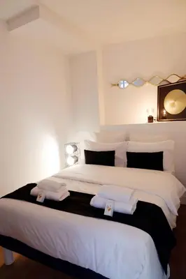a bedroom with a large white bed with towels on it at Au coeur du vieux Cannes - 2 pièces - 4 couchages - 500 m du Palais des Festivals in Cannes