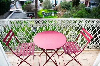 two pink chairs and a pink table on a balcony at Sunny Duplex by Connexion in Cannes