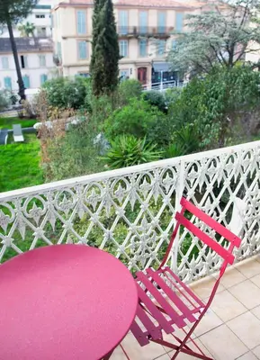 a red table and a red bench on a white fence at Sunny Duplex by Connexion in Cannes