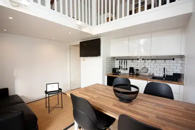a kitchen and dining room with a wooden table and chairs at Sunny Duplex by Connexion in Cannes
