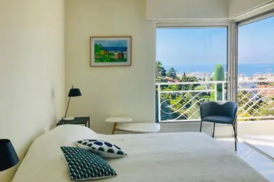 a bedroom with a bed and a large window at Sea view apartment-3 pers-with pool-Cannes in Cannes