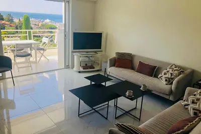 a living room with a couch and a television at Sea view apartment-3 pers-with pool-Cannes in Cannes